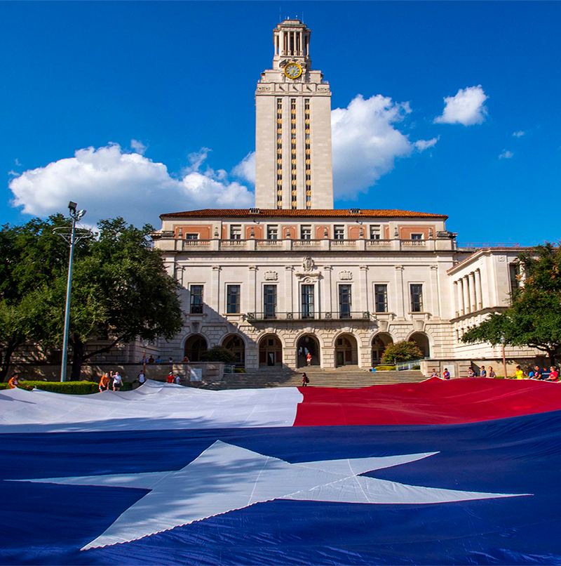 Large Texas flag sprawling in front of UT Tower