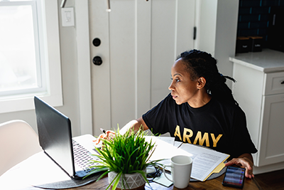 black female veteran studying on laptop at table
