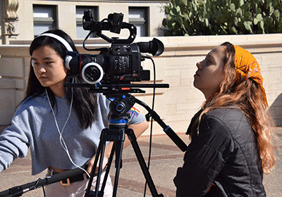 two students setting up camera and audio equipment