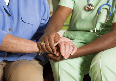 health care professional holding hands with patient