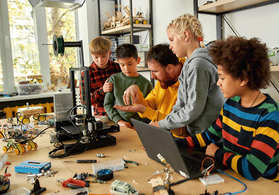 teacher and elementary students in robotics lab