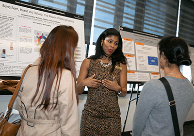 Student presenting informative poster to peers