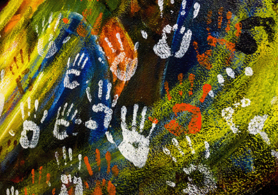 Mural of painted handprints on a colorful background