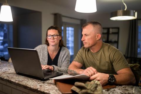 military veteran and spouse sitting at computer