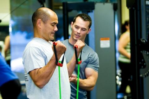 personal trainer guiding patient through exercise