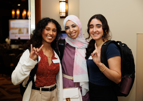 students showing hook'em hand sign