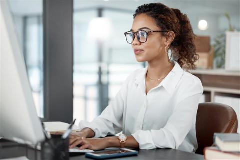 professionally dressed woman typing at desk