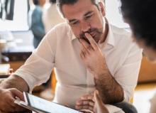 professional colleagues discuss data on tablet