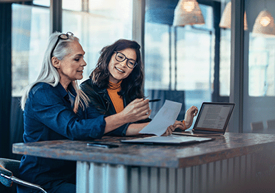 two women discuss a report