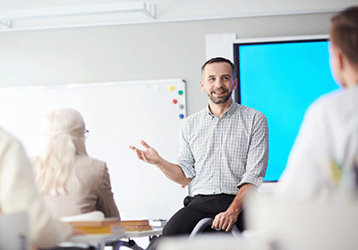 man speaking in front of colleagues