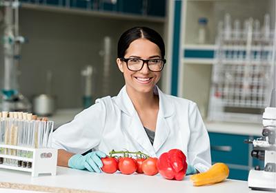 nutritionist in lab with tomatoes and various vegetables