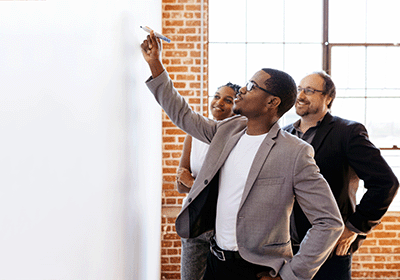 coworkers starting to brainstorm on blank whiteboard