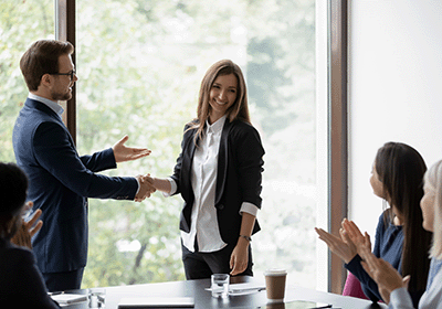 peers congratulate colleague on accomplishment