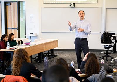 Person lecturing to a small group in a seminar room