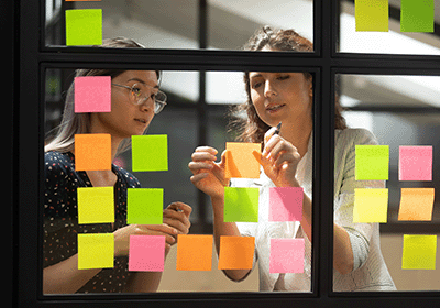 Professionals plan strategy using sticky notes