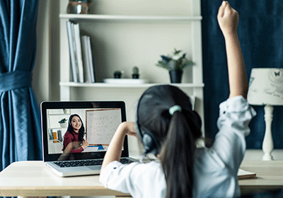 elementary student raises hand during virtual class