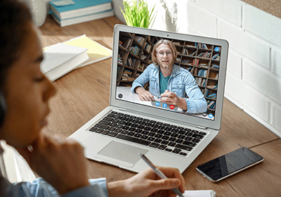teacher on laptop screen coaching student