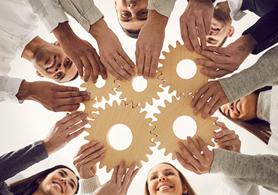 team holding wooden gears together