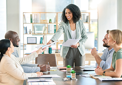 Woman presenting reports to coworkers