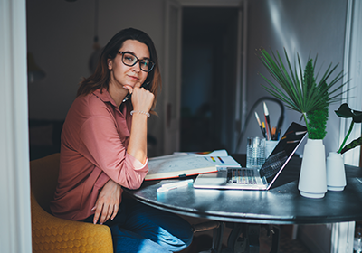 Woman studying with laptop and textbooks