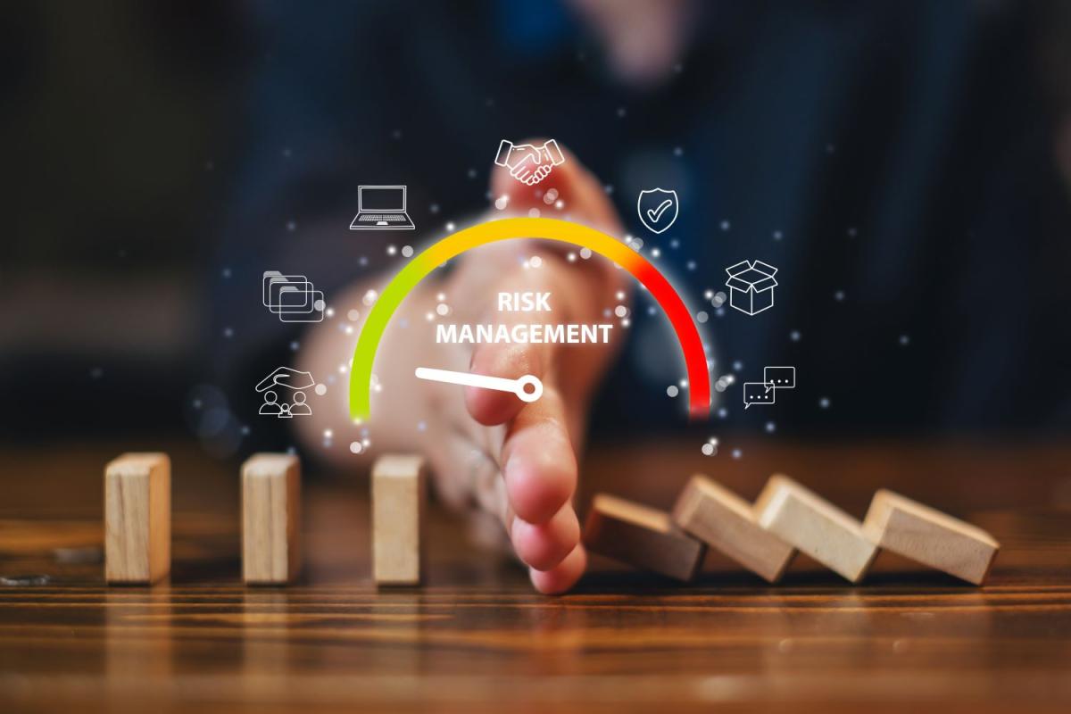 hand stopping dominoes from falling. text overlay "Risk Management"