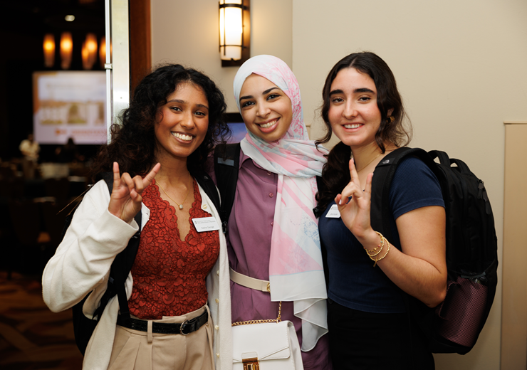 students showing hook'em hand sign