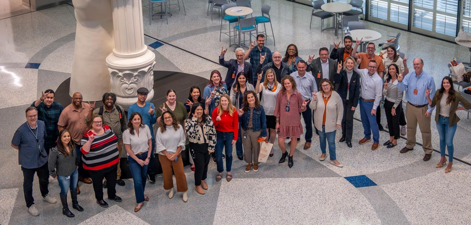 aerial shot of group of people in office lobby showing hook 'em sign