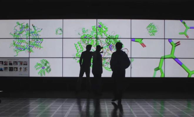 three silhouettes against illuminated panels displaying molecules