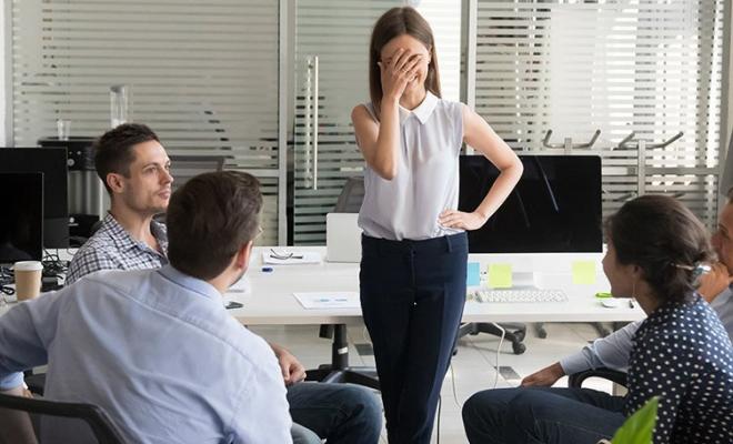 Professional covering face embarrassed in front of colleagues