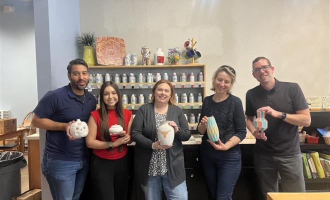 people displaying pottery pieces in studio