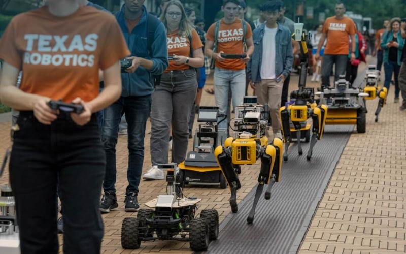 UT robotics Students parading robots along Speedway 