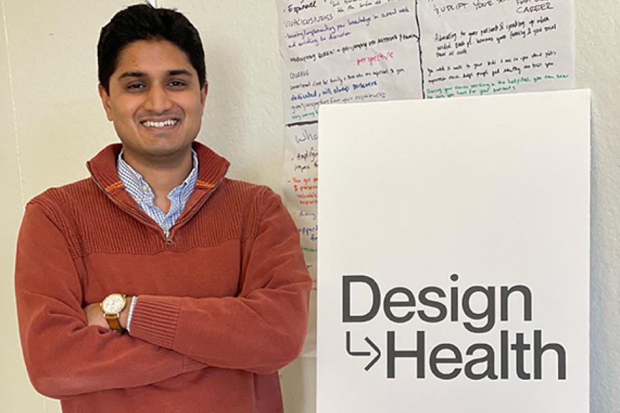 Nikhil Mahadevan standing next to "Design Health" sign
